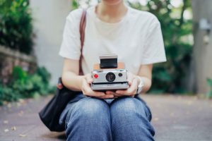 Slow Tech: woman holding polaroid camera
