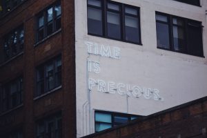Neon sign saying 'time is precious' - the attention economy